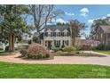 Beautiful two-story house with black shutters, dormers, lush landscaping and a circular driveway at 3133 Selwyn Ave, Charlotte, NC 28209