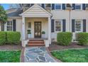 Inviting front porch with brick steps, bluestone path, white columns, and dark wood front door at 3133 Selwyn Ave, Charlotte, NC 28209