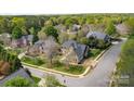 Expansive aerial view of a brick house nestled in a lush, green neighborhood with mature trees and well-manicured lawns at 3304 Taviston Dr, Waxhaw, NC 28173