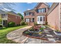 Traditional brick home featuring lush landscaping, a small bridge over the decorative water feature, and inviting curb appeal at 3304 Taviston Dr, Waxhaw, NC 28173