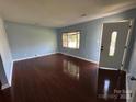 Well-lit living room with hardwood floors, bay window, and a bright front door at 3915 Crestridge Dr, Charlotte, NC 28217