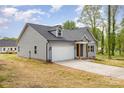 Side view of a house with gray siding, black roof, and a white two-car garage at 409 Bost St, Kannapolis, NC 28081
