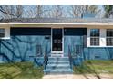 Close-up of a classic blue brick home with a black front door and matching railings at 4931 Galax Dr, Charlotte, NC 28213