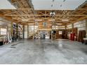Large garage interior featuring a concrete floor, exposed wooden beams, staircase and ample space for storage or workshop at 5412 Carving Tree Dr, Harrisburg, NC 28075