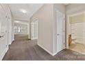 Bright hallway featuring neutral walls, carpet flooring, and doors leading to various rooms at 6615 Buck Horn Pl, Waxhaw, NC 28173