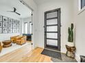 Bright foyer with wood floors, designer cactus, and black framed door leading into living area at 805 E 19Th St, Charlotte, NC 28205