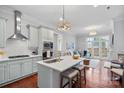 Modern kitchen featuring a breakfast bar, stainless steel appliances, and seamless open floor plan to living room at 8812 Provence Village Ln, Charlotte, NC 28226