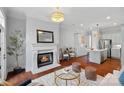 Inviting living room featuring a fireplace, an open layout to kitchen and gleaming hardwood floors at 8812 Provence Village Ln, Charlotte, NC 28226