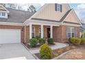 Inviting home entrance featuring a brick facade, manicured landscaping and covered porch at 8823 Bur Ln, Huntersville, NC 28078