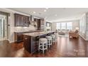 Open-concept kitchen with a large center island, granite countertops, and dark wood cabinetry at 8823 Bur Ln, Huntersville, NC 28078
