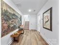 Inviting foyer with wood floors and a charming bench provides access to upper level at 9239 Delancey Nw Ln, Concord, NC 28027