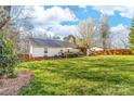 Expansive backyard featuring a spacious lawn, a deck, and a covered outdoor living area, ideal for relaxation at 1025 Hunter Valley Rd, Shelby, NC 28150
