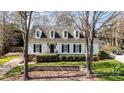 Beautifully landscaped home with symmetrical dormer windows, black shutters, and lush green lawn at 10332 Hollybrook Dr, Charlotte, NC 28277