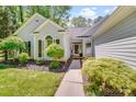 Welcoming front exterior featuring a landscaped walkway leading to the front door and a charming arched window at 11003 Pale Hickory Ln, Charlotte, NC 28215