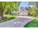 Attractive home with a well-kept lawn, mature trees, and a two-car garage at 11003 Pale Hickory Ln, Charlotte, NC 28215