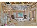 Exposed framing and pink insulation showcase the interior of a home under construction with natural light at 1235 E Poplar St, Conover, NC 28613