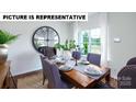 Bright dining room with a wooden table, stylish chairs, and a large window at 132 Woodhall Way, Troutman, NC 28166