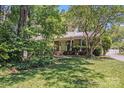 Traditional home featuring a lush, green lawn, mature trees and a charming front entrance at 1327 Cedarwood Ln, Charlotte, NC 28212