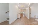 Bright hallway featuring wood floors, a staircase, and an open view to the living room at 13625 Buster Rd, Stanfield, NC 28163