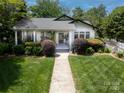Beautiful home with a verdant front yard and walkway leading to the charming entrance at 1519 The Plz, Charlotte, NC 28205