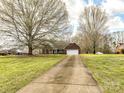 Charming brick home with an attached two-car garage, long drive, mature trees, and a well-maintained lawn at 1520 Venture Oaks Ln, Monroe, NC 28110