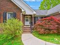 Inviting front entrance showcasing brick steps, a white door, and lush landscaping at 1520 Venture Oaks Ln, Monroe, NC 28110