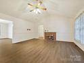 Open living room with vaulted ceilings, cozy fireplace, and wood-look flooring at 1520 Venture Oaks Ln, Monroe, NC 28110
