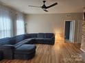 Spacious living room featuring a large sectional sofa, ceiling fan and plenty of natural light at 190 Glastonbury Dr, Mooresville, NC 28115