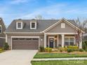 Charming home featuring a two-car garage, dormer windows and a welcoming front porch, perfect for suburban living at 2011 Trailwood Dr, Matthews, NC 28104
