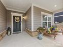 Inviting front porch with neutral siding, decorative wreath, and comfortable seating, perfect for relaxing outdoors at 2011 Trailwood Dr, Matthews, NC 28104