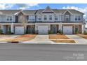 Street view of modern townhomes each featuring attached garages, diverse architectural finishes, and manicured landscaping at 2149 Bexar Trl, Matthews, NC 28105