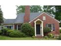 Close-up of a charming brick home with a landscaped front yard and a black front door at 2815 Glendale Rd, Charlotte, NC 28209