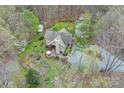 Expansive wooded lot with lush landscaping, charming outbuilding, inviting patio with outdoor furniture, and a winding driveway at 2819 Blythe Rd, Waxhaw, NC 28173