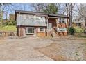 Charming split-level home featuring a brick facade, gray siding, and a spacious driveway at 326 Whispering Pines Dr, Charlotte, NC 28217