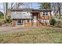 Charming split-level home featuring a brick facade, gray siding, and a well-manicured lawn at 326 Whispering Pines Dr, Charlotte, NC 28217