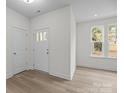 Bright entryway features wood-look flooring, white walls, and a front door with glass pane detailing at 4127 Walking Ridge Rd # 53, Charlotte, NC 28208
