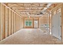 Unfinished living room shows the wall and ceiling construction, window, and exterior door at 5005 County Home Rd, Conover, NC 28613