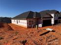 View of a new construction home with black roof and siding barrier ready for exterior finishing at 713 Inwood Hill Dr # 96, Gastonia, NC 28056