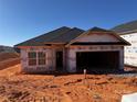 View of a new construction home with black roof and siding barrier ready for exterior finishing at 713 Inwood Hill Dr # 96, Gastonia, NC 28056