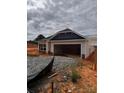 New construction home with white siding, black roof, and an open garage door at 713 Inwood Hill Dr # 96, Gastonia, NC 28056