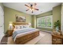Comfortable bedroom with large window, warm green walls, wood furniture, and pleasant natural light at 8617 Coralbell Ln, Charlotte, NC 28213