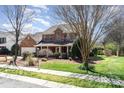 Beautiful brick home featuring a covered front porch and a lush, green lawn at 8622 Ellington Park Dr, Charlotte, NC 28277