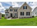 Charming two-story home with white brick, black shutters, and a well-manicured front lawn at 873 Penny Royal Ave, Fort Mill, SC 29715