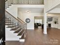 Grand foyer showcasing hardwood floors, a staircase with iron railings, and a view into the living room at 873 Penny Royal Ave, Fort Mill, SC 29715