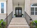 Elegant entryway featuring a dark double door, brick steps, and black iron railings at 873 Penny Royal Ave, Fort Mill, SC 29715