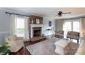Comfortable living room with a brick fireplace, stylish seating, and large windows at 9709 Cloverwood Ct, Charlotte, NC 28270