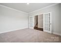 Versatile room with plush carpeting, leading through French doors to staircase at 9940 Manor Vista Trl, Kannapolis, NC 28027