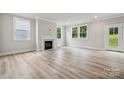 Bright living room features light wood floors, a fireplace, and large windows offering serene outdoor views at 9940 Manor Vista Trl, Kannapolis, NC 28027