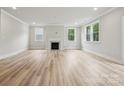 Bright living room features light wood floors, a fireplace, and large windows offering serene outdoor views at 9940 Manor Vista Trl, Kannapolis, NC 28027
