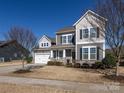 Charming two-story home featuring manicured landscaping, gray siding, stone accents, and a two car garage at 1022 Doughton Ln, Indian Trail, NC 28079